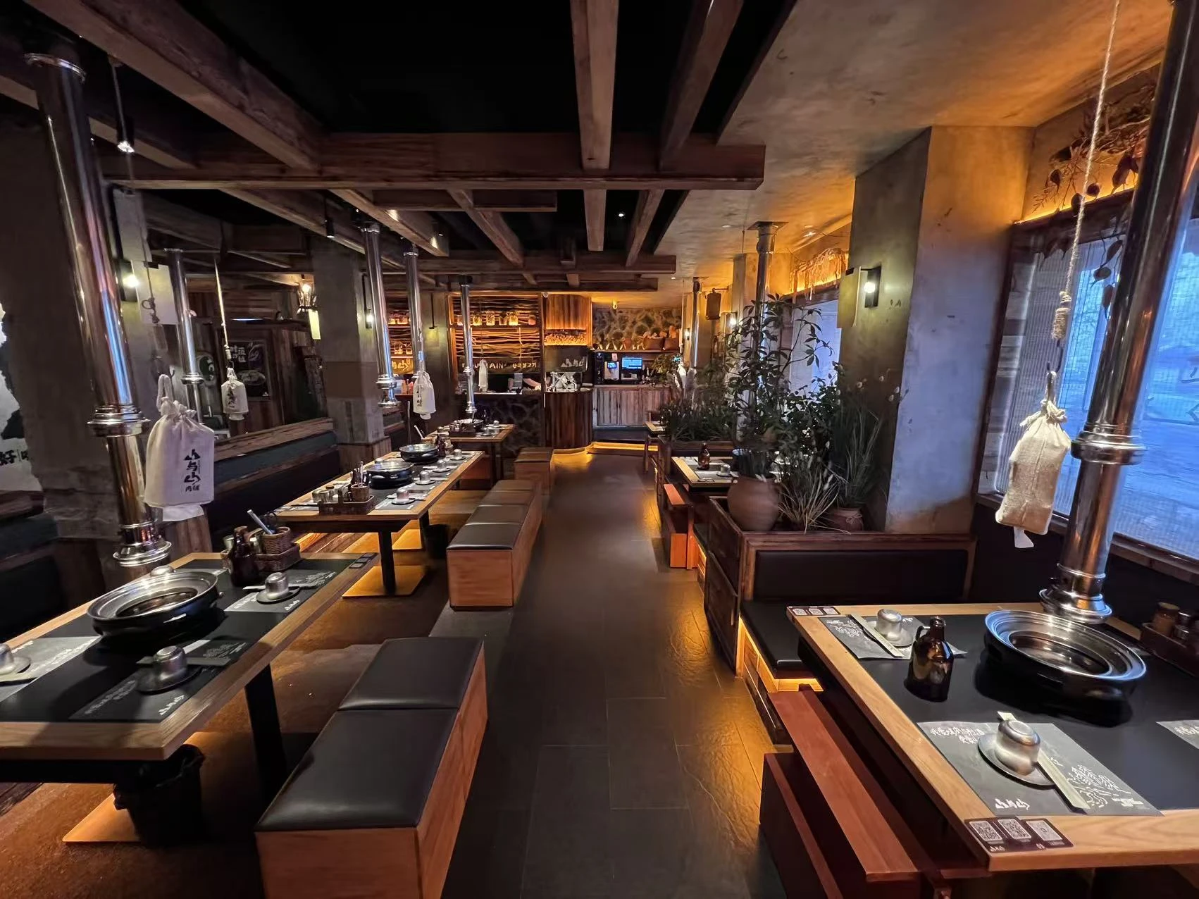 山与山肉铺丹东店实景,展示木材、岩石与就餐空间